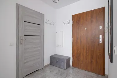 a room with a door and a stool next to a door at Kraków Elegant Apartment Near The Water Park by Rent like home in Kraków