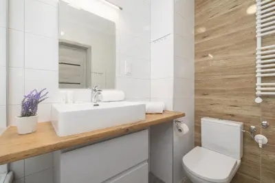 a bathroom with a white sink and a toilet at Kraków Elegant Apartment Near The Water Park by Rent like home in Kraków