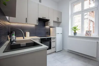a white kitchen with a sink and a refrigerator at Old Town Apartment Kazimierz in Kraków