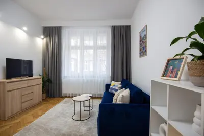 a living room with a blue couch and a tv at Old Town Apartment Kazimierz in Kraków