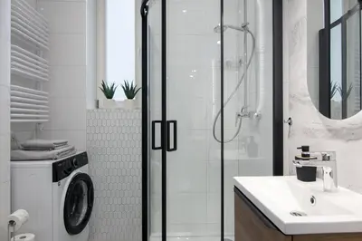 a bathroom with a shower and a washing machine at Old Town Apartment Kazimierz in Kraków