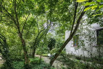 a building in the middle of a forest of trees at Garden House Apartments in Kraków