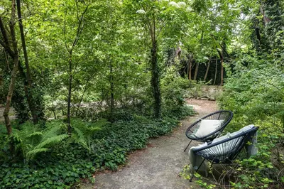 a bench sitting on a path in a garden at Garden House Apartments in Kraków