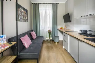 a living room with a couch and a kitchen at Garden House Apartments in Kraków