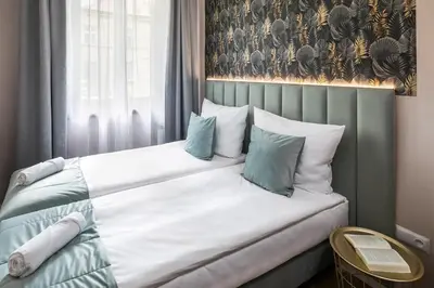 a bedroom with a bed with white and blue pillows at Garden House Apartments in Kraków