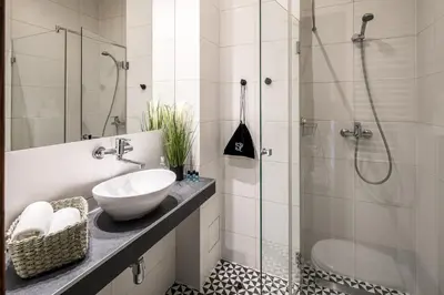a white bathroom with a sink and a shower at Garden House Apartments in Kraków