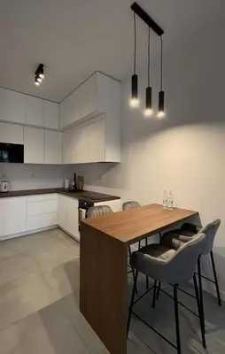 a kitchen with a wooden table and chairs at Apartament Orawska in Kraków
