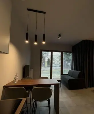 a living room with a table and chairs and a couch at Apartament Orawska in Kraków