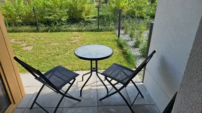 a patio with a table and two chairs on a porch at Apartament Orawska in Kraków