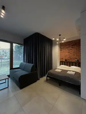 a bedroom with a bed and a couch at Apartament Orawska in Kraków