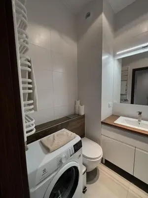a washing machine in a bathroom with a toilet and a sink at Apartament Orawska in Kraków