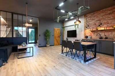 a kitchen and living room with a table and chairs at Aparthotel Mamma Mia - Oświęcim in Oświęcim