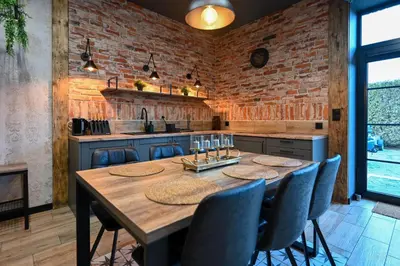 a kitchen with a wooden table and blue chairs at Aparthotel Mamma Mia - Oświęcim in Oświęcim