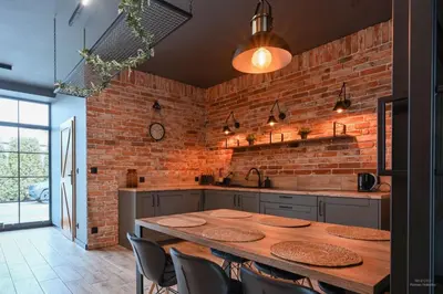 a kitchen with a wooden table and a brick wall at Aparthotel Mamma Mia - Oświęcim in Oświęcim