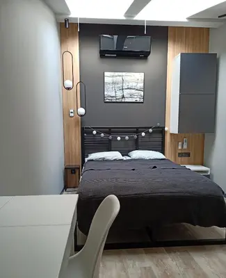 a bedroom with a black bed and a white desk at Apartments in the heart of the city in Kraków