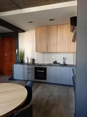 a kitchen with wooden cabinets and a wooden table at Apartments in the heart of the city in Kraków