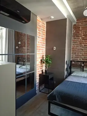 a bedroom with a bed and a brick wall at Apartments in the heart of the city in Kraków