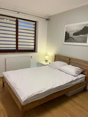 a bedroom with a large white bed and a window at Bianco Apartament Reduta Park Free Parking in Kraków