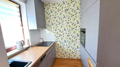 a kitchen with a sink and a mosaic wall at Bianco Apartament Reduta Park Free Parking in Kraków
