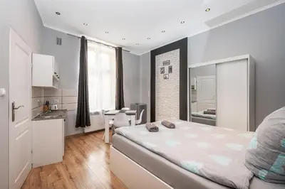 a bedroom with a large bed and a kitchen at 70s Business Room in Kraków