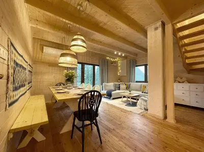 a dining room and living room with a table and chairs at Panorama Sucha Góra in Skawica