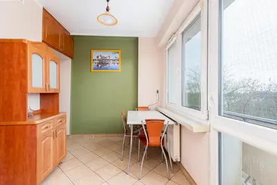 a kitchen with a table and chairs and a window at Zielona Nowa Huta Apartment by BookingHost in Kraków