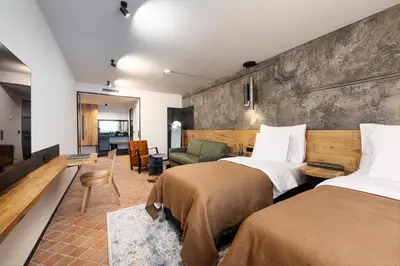 a hotel room with two beds and a couch at Nomadic Urban Premium Suites in Kraków