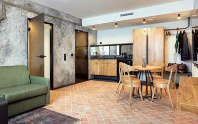 a kitchen and living room with a table and chairs at Nomadic Urban Premium Suites in Kraków
