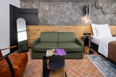 a bedroom with a green couch and a bed at Nomadic Urban Premium Suites in Kraków