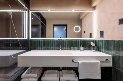 a bathroom with a large white sink and a mirror at Nomadic Urban Premium Suites in Kraków