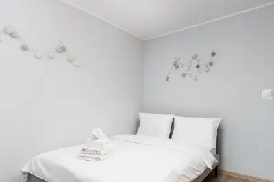 a white bedroom with a bed with white sheets at Krowoderskich Zuchów Standard Studio by BookingHost in Kraków