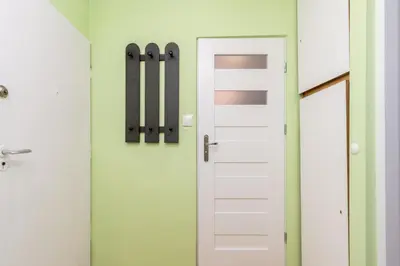 a door in a bathroom with green walls at Krowoderskich Zuchów Standard Studio by BookingHost in Kraków