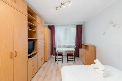 a bedroom with a bed and a table and a television at Krowoderskich Zuchów Standard Studio by BookingHost in Kraków