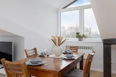 a dining room with a wooden table and a window at Apartment with 2 Bedrooms and Desks in the Center of Cracow by Noclegi Renters in Kraków