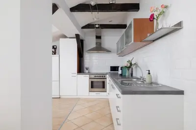 a kitchen with white cabinets and a sink at Apartment with 2 Bedrooms and Desks in the Center of Cracow by Noclegi Renters in Kraków