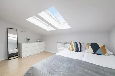 a white bedroom with a bed and a skylight at Apartment with 2 Bedrooms and Desks in the Center of Cracow by Noclegi Renters in Kraków