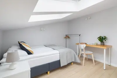 a white bedroom with a bed and a desk at Apartment with 2 Bedrooms and Desks in the Center of Cracow by Noclegi Renters in Kraków