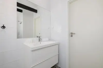 a white bathroom with a sink and a mirror at Apartment with 2 Bedrooms and Desks in the Center of Cracow by Noclegi Renters in Kraków