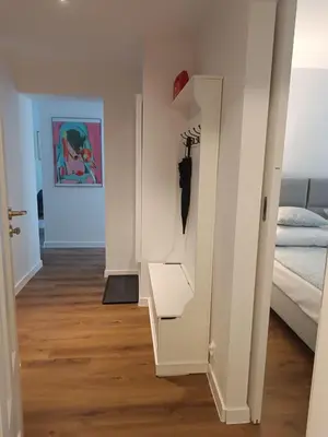 a hallway with a white room with a bed and a closet at Close to everywhere, cosy place in Kraków