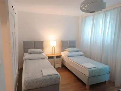 a bedroom with two beds and a table with a lamp at Close to everywhere, cosy place in Kraków