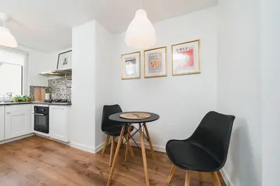 a kitchen with a table and chairs in a room at Close to everywhere, cosy place in Kraków