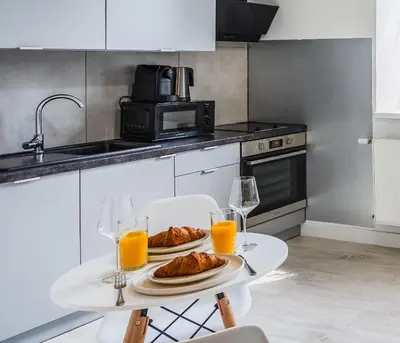a kitchen with a table with food and glasses of orange juice at Apartment Quiet Street 11/5E in Oświęcim
