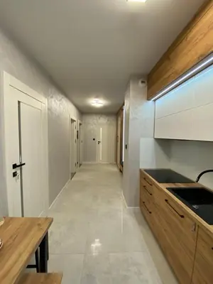 a kitchen with white walls and a long hallway at Przewóz Lux Lucky Apartments Garaż w cenie in Kraków