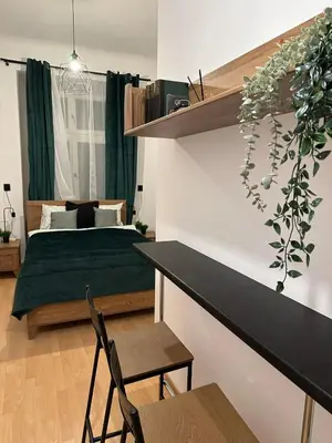 a bedroom with a bed and a table and chairs at Wielopole Classy Rooms in Kraków