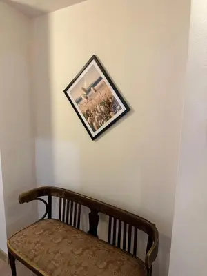 a picture hanging on a wall next to a bench at Wielopole Classy Rooms in Kraków