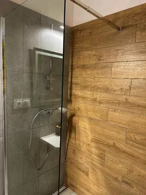 a bathroom with a shower with a glass wall at Wielopole Classy Rooms in Kraków