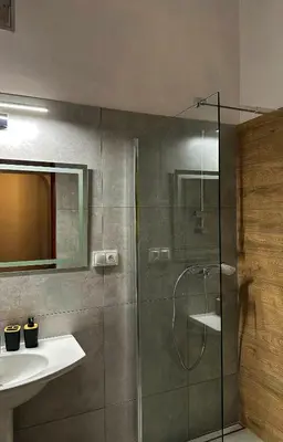 a bathroom with a glass shower and a sink at Wielopole Classy Rooms in Kraków