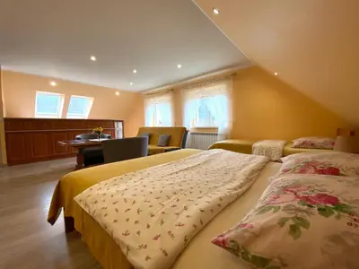 a bedroom with two beds and a table and chairs at Apartamenty i pokoje w Zawoi Dorota Miśkowiec in Zawoja