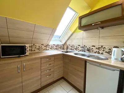 a small kitchen with a sink and a microwave at Apartamenty i pokoje w Zawoi Dorota Miśkowiec in Zawoja