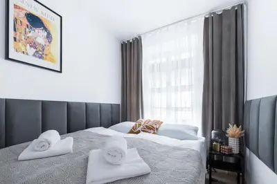 a bedroom with two beds with towels and a window at Józefa 12 Apartments in Kraków